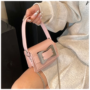 Macro detail of pink PU leather mini square bag featuring a large silver metal buckle strap