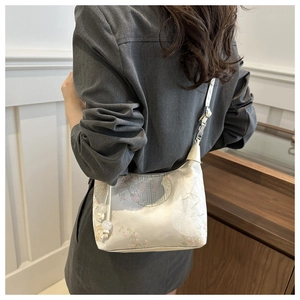 Détail du sac brodé de style chinois avec motifs floraux et breloque en perles raffinée