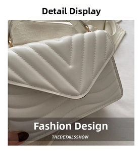 Detailed close-up of white leather handbag featuring V-shaped quilting and gold hardware