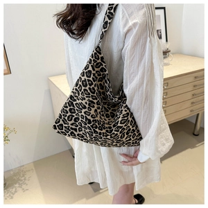 Detailed view of leopard print tote bag fabric showing texture and shoulder strap fit