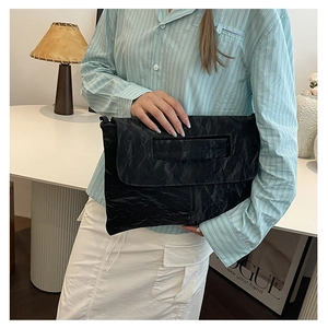 Détail du sac à main noir avec design à rabat et poignée ergonomique pour le confort