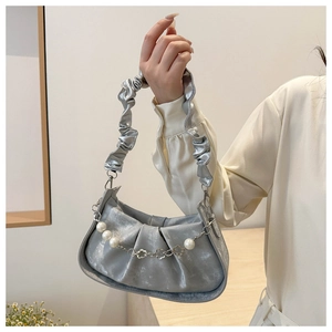 Detail view of metallic silver cloud bag with decorative pearl and metal flower chain