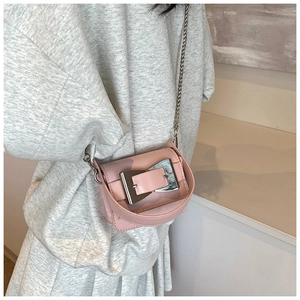 Pink leather mini crossbody bag with silver buckle and metal chain strap on model