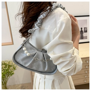 Detail of silver pleated crossbody bag featuring pearl chain and ruched shoulder strap