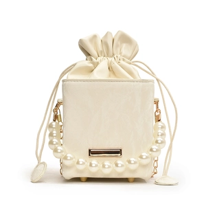Elegant cream drawstring bucket bag with pearl handle and golden chain strap for summer