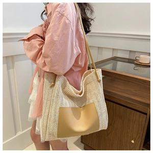Detail of woven tote bag featuring a leather patch pocket and slim shoulder straps