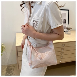 Gros plan du sac à bandoulière en jacquard rose avec broderie de paysage et perles chic