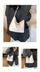Detail of white matte leather hobo bag with unique decorative thick rope knot handle