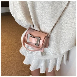 Detailed shot of pink mini crossbody bag with silver buckle and chain strap on model
