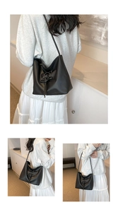 Detail of minimalist black matte bucket bag featuring cross-tied lacing and soft PU texture