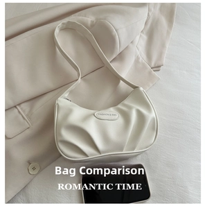 Detail view of cream pleated underarm bag with fashion brand label and leather texture