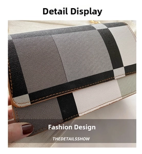 Detail view of classic plaid pattern and precise brown edge stitching on shoulder bag