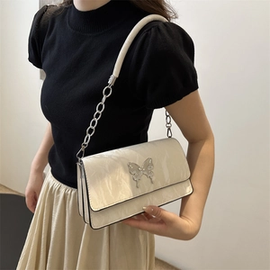 Chic beige quilted shoulder bag featuring silver butterfly clasp and metal chain strap