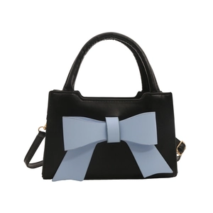 Fashionable black faux leather handbag with a large blue bow and golden hardware