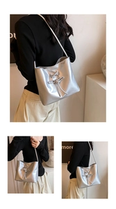 Detail view of silver PU leather bucket bag with ribbon bow and shiny metallic finish