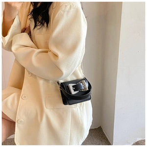 Close-up of black leather mini square bag with oversized silver buckle and chain