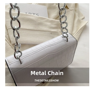 Detail of silver chain strap connected to white stone texture crossbody bag leather