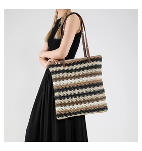 Dettaglio della borsa tote intrecciata boho con strisce colorate e manici in pelle