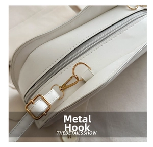 Detail shot of the gold metal hook and fine white leather texture of the bag
