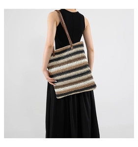Dettaglio della borsa tote a righe intrecciate con manico in pelle marrone e design