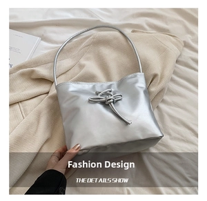 Détail du sac sous le bras argenté métallisé avec boucle à nœud élégante sur le devant