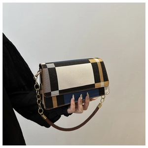 Close-up of color-block flap bag featuring a gold chain and premium leather texture