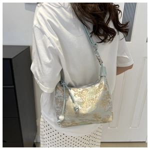 Détails de broderie de palais chinois et de pin sur un sac à bandoulière bleu clair