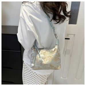 Détail du sac à bandoulière bleu clair avec gland en perles et broderie de paysage dorée