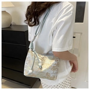 Détail du sac à main vert menthe avec broderie florale dorée et accents de perles