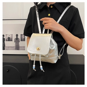 Detail of silver mini backpack with metallic finish and gold twist lock closure