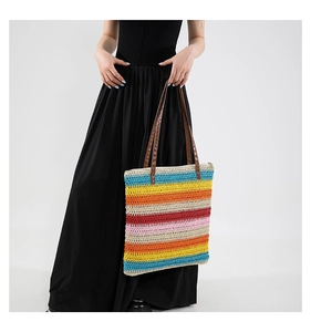 Dettaglio della trama della borsa tote intrecciata a righe arcobaleno con manici in pelle