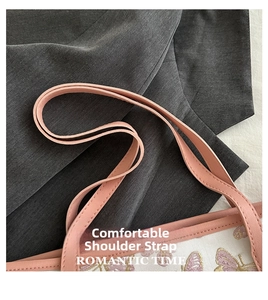 Close-up of pink butterfly embroidery and premium leather strap on cream tote bag