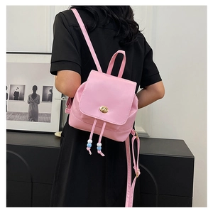 Pink PU leather mini backpack with gold twist lock and beaded drawstring on model