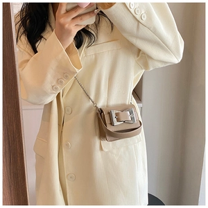 Close-up of the beige mini chain crossbody bag showing silver buckle and leather texture