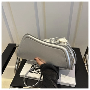Detailed view of silver metallic crescent shoulder bag with golden brand lettering