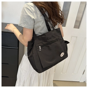 Black canvas tote bag with front pocket and good luck logo for daily commuting and campus use