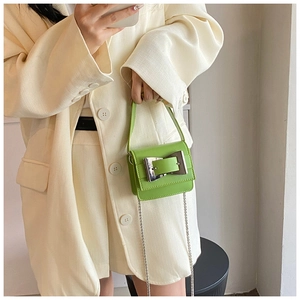 Detail view of a neon green mini chain bag featuring a large silver square buckle and strap