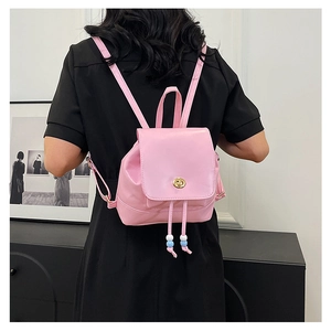 Rear view of a pink mini backpack with golden twist lock and beaded drawstring details