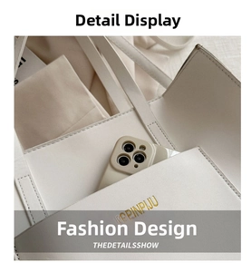 Detail view of white leather tote bag interior pocket and golden brand logo engraving