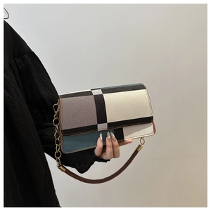 Detailed view of color-block geometric pattern and metallic chain on the shoulder bag