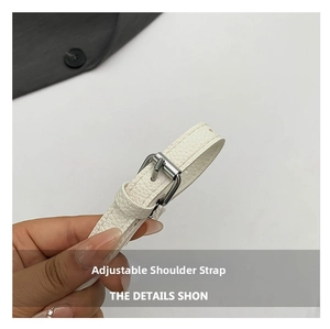 Detail of adjustable white lychee textured leather strap with silver metal buckle