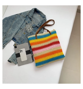 Close-up of colorful striped woven tote with leather straps and spacious interior detail
