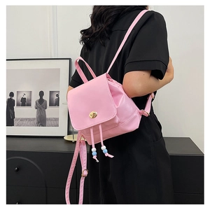 Detailed shot of pink mini backpack featuring gold turn-lock and pastel bead drawstrings