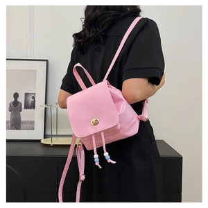 Pink mini backpack detail with golden twist lock and beaded drawstring on glossy PU leather