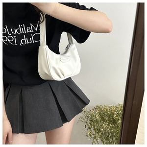 Close-up of white crescent shoulder bag with smooth leather finish and zipper detail