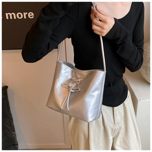 Détails du sac seau argenté montrant la texture métallique et le nœud décoratif