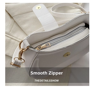 Close-up of white semi-circle saddle bag showing smooth zipper and gold hardware detail