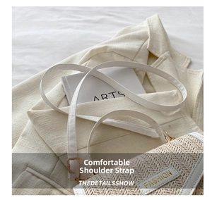 Detail of cream woven shoulder bag featuring white leather strap and golden metal buckle