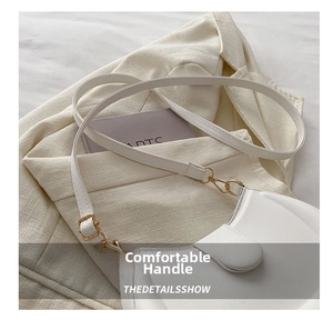 Detail shot of a white PU leather shoulder bag with a gold metal clasp on a beige suit