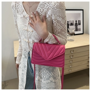 Detailed macro view of hot pink chevron quilted leather handbag with gold metal hardware